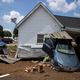 Vehicles are piled up next to a house destroyed by flooding on Aug. 23, 2021 in Waverly, Tennessee.